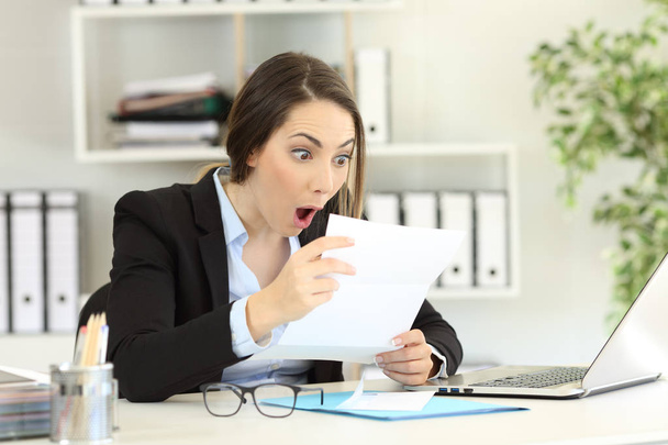 Amazed office worker reading good news a letter - Фото, изображение