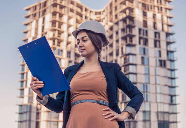 femme d'affaires béatifique ingénieur est debout avec des papiers de plan
. - Photo, image