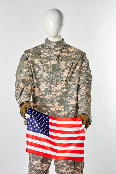 Mannequin in military army uniform holding american flag. - Foto, Imagem