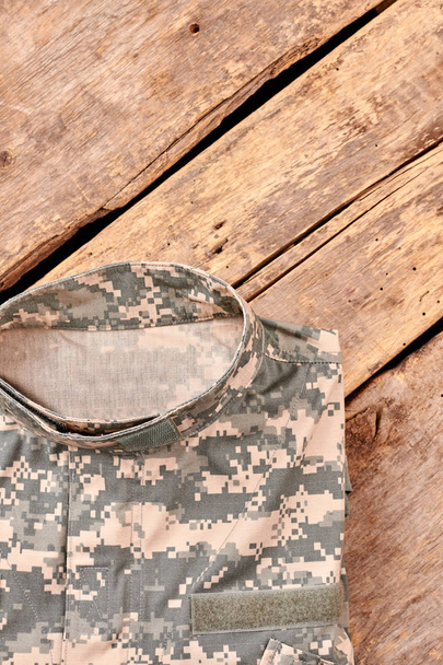 Folded military clothes on wood. - Photo, Image