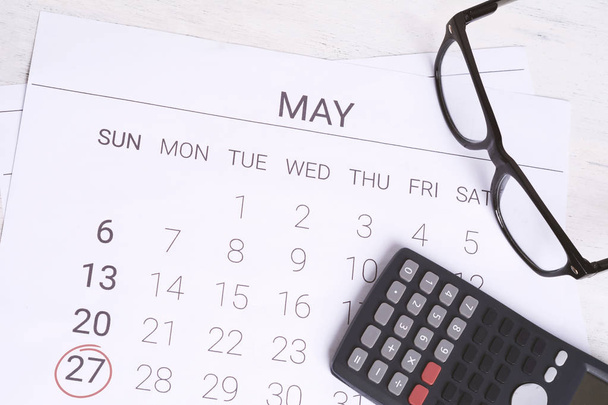 Calendar to remind you an important appointment with calculator in May. Financial planning, business concept. - Foto, afbeelding