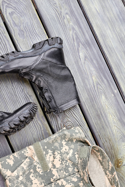 Солдатская одежда, камуфляж и боевые сапоги
. - Фото, изображение
