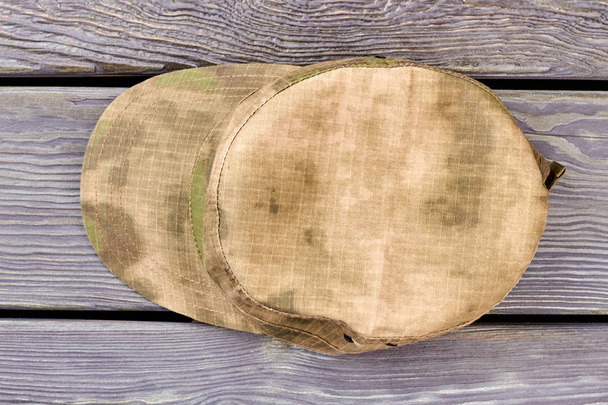 Gorra militar sobre madera, vista superior
. - Foto, Imagen