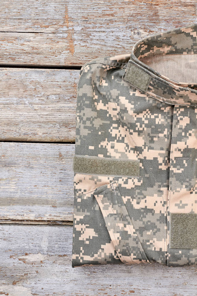 Camouflage military cloth on wood. - Zdjęcie, obraz
