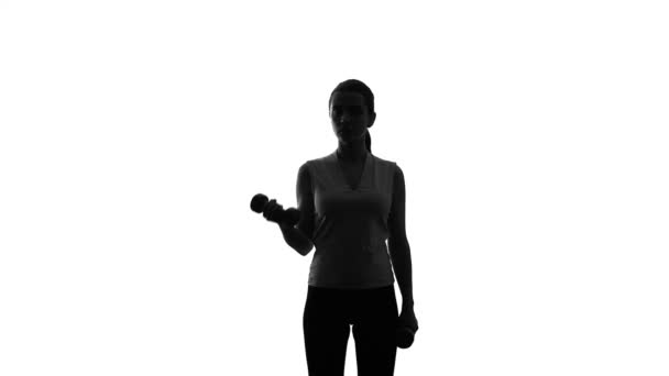Silhouette of female athlete lifting dumbbells to lose weight, sport and workout - Filmmaterial, Video