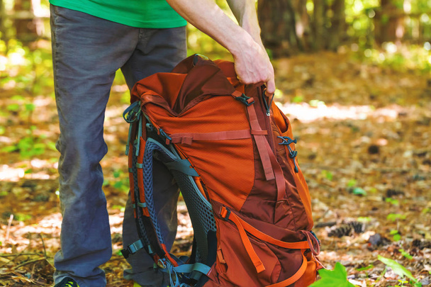 Hiker holding his camping backpack - Foto, afbeelding