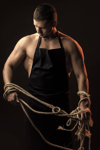 Male Face. Issues affecting boy. Muscular man in apron with rope - Фото, изображение