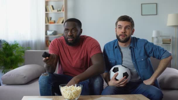 Two soccer fans watching american football match, trying to understand rules - Filmmaterial, Video
