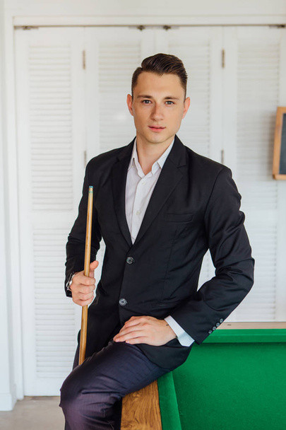 Young handsome man dressed in classic costume playing billiard game alone - Fotografie, Obrázek