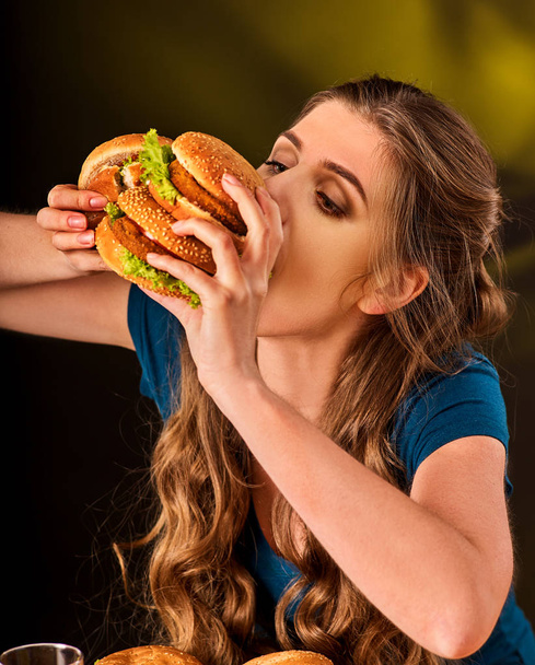 Woman eating french fries and hamburger with pizza. - Photo, Image