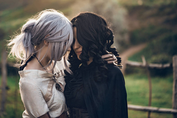 Fantasía cosplay dos hermosas chicas abrazo en la naturaleza
 - Foto, Imagen