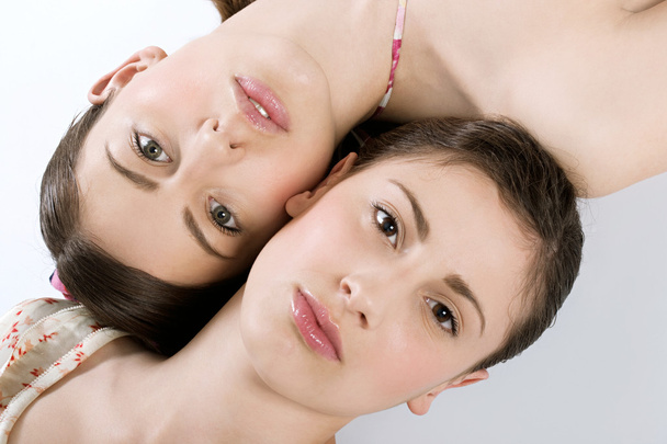portrait de deux jeunes femmes avec une peau parfaite couchée l'une à côté de l'autre
 - Photo, image