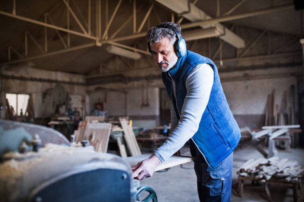 A man worker in the carpentry workshop, working with wood. - Φωτογραφία, εικόνα