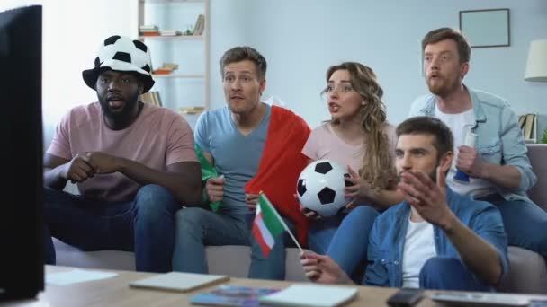 Multiracial Italian fans sitting on sofa and watching game, celebrating goal - Filmagem, Vídeo