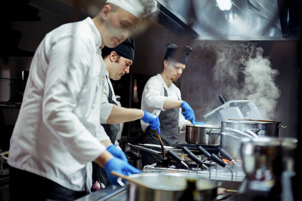 Group of chefs working in the kitchen - Foto, Bild