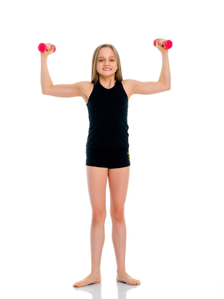Teenage girl with dumbbells in hands - Photo, Image
