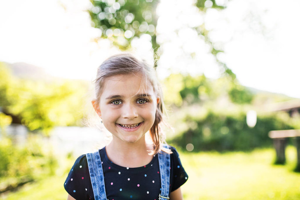 A portrait of a small girl in the garden in spring nature. - Fotoğraf, Görsel
