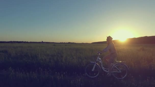 アクティブなスタイリッシュな女性は太陽の下で自転車に乗る - 映像、動画