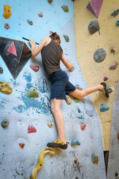 Adolescente niño entrenamiento escalada en interior escalada pared
 - Foto, imagen