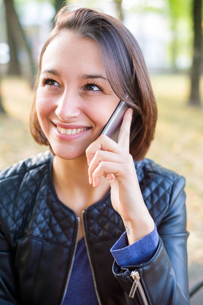 Kobieta Twarz portret uśmiecha się i rozmawia przez telefon - Zdjęcie, obraz
