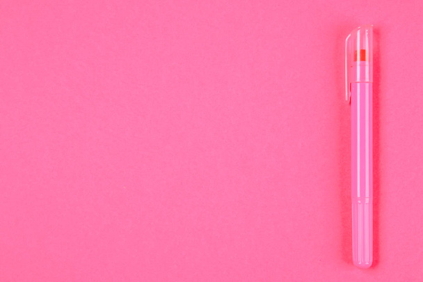 Pink felt-tip pen on a pink pastel background. Summer. Top view. Flat lay. Copy space - 写真・画像