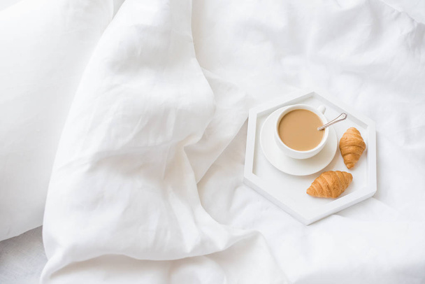 Ranní snídani v posteli, kávu a croissant na hlavním panelu - Fotografie, Obrázek