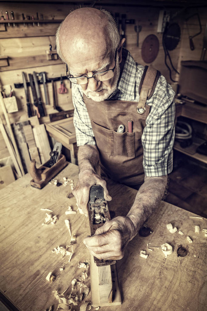 senior carpenter use handplaner in his workshop - Fotó, kép