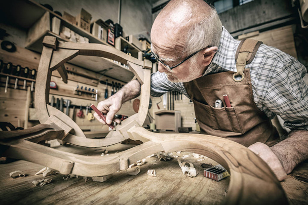 old woodworker at work in workshop - Fotó, kép