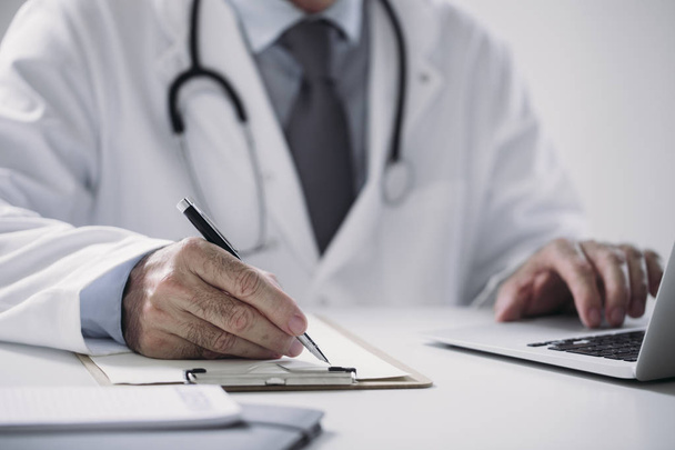 Hands of unrecognisable man physician writing at office. - Photo, image