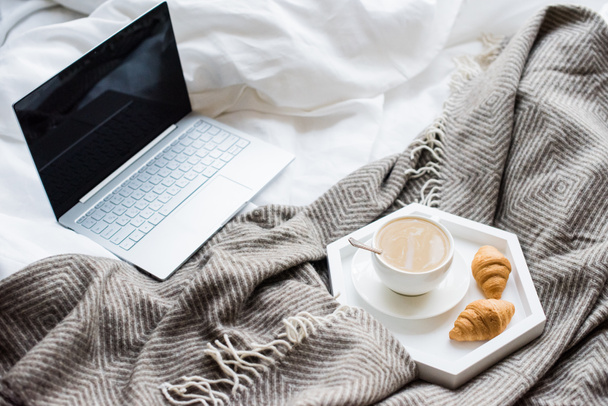 Gezellig weekend thuis, laptop en koffie in bed - Foto, afbeelding