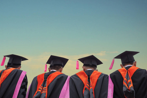 выпускники шапки за ясным голубым небом, выпускники стоят в очереди на кампусе
 - Фото, изображение