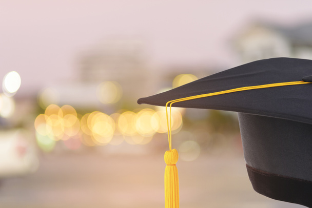 Graduation cap met gouden franje op abstracte bokeh achtergrond wazig - Foto, afbeelding