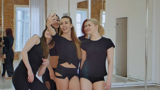 Mooie jonge vrouwen nemen van een selfie tijdens een vakantie op een paal fitness klasse - Foto, afbeelding