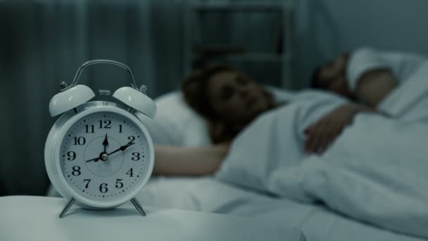 Married couple peacefully sleeping at night with clock near bed, sleep phases - Video, Çekim