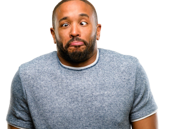 Afro-amerikai férfi szakállal, hogy vicces arcot bolondozás elszigetelt fehér háttér felett - Fotó, kép