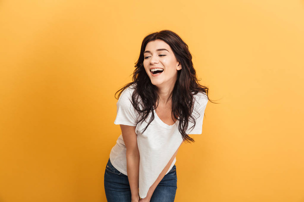 Photo of happy young pretty woman standing isolated over yellow background looking aside. - Foto, imagen