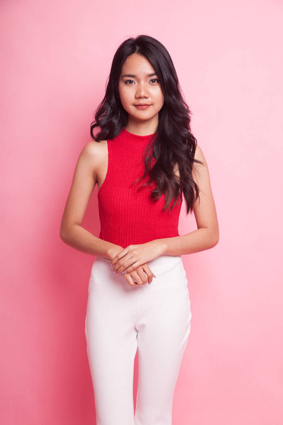 Retrato de una hermosa joven asiática con camisa roja sobre fondo rosa
 - Foto, Imagen