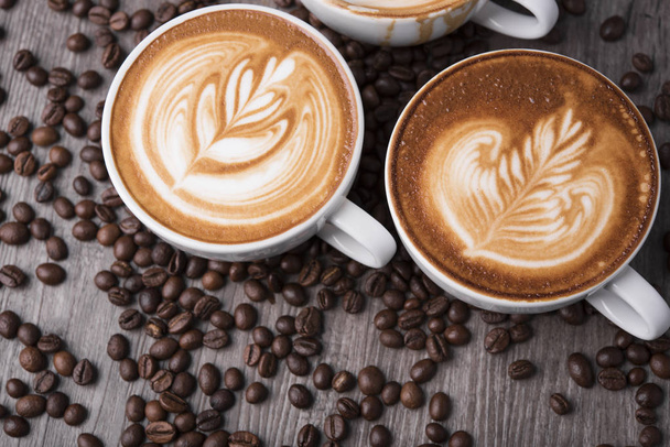 latte vagy Cappuccino habos habbal, kávé csésze tetejére néző asztalon kávézóban. - Fotó, kép