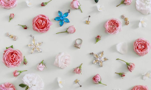 bellissimi gioielli per le donne, fiori su uno sfondo di colore chiaro
 - Foto, immagini