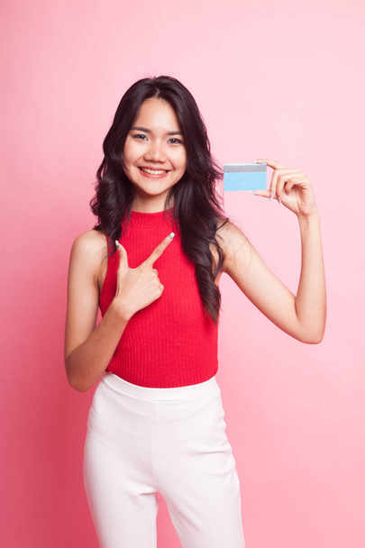 Young Asian woman point to a blank card on pink background - Φωτογραφία, εικόνα