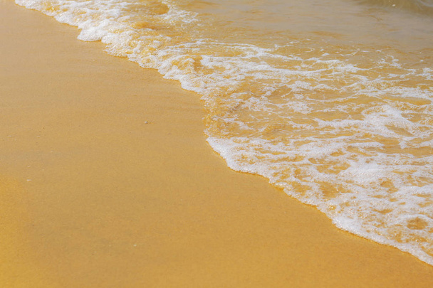 Gelber Sand und Wellen am Meer. - Foto, Bild