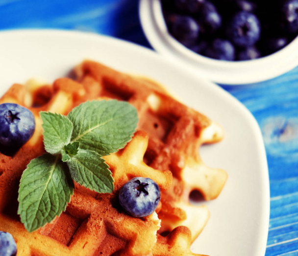 Homemade belgian waffles with fresh blueberry and raspberry over wooden background. - Foto, immagini