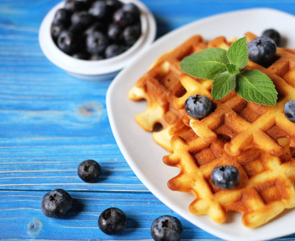 Homemade belgian waffles with fresh blueberry and raspberry over wooden background. - Foto, Imagen