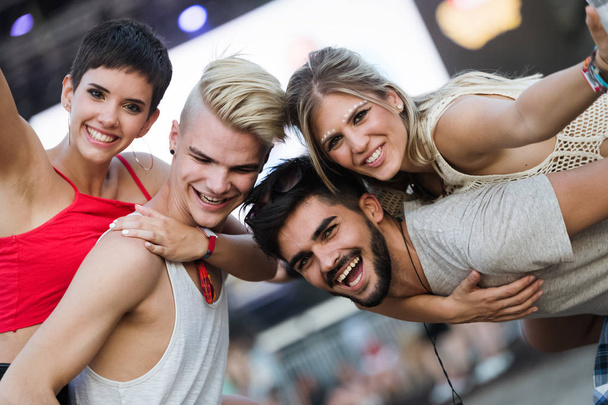 Happy young friends having fun at music festival - Foto, imagen