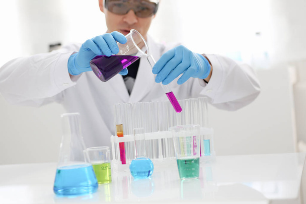 Un chimiste masculin tient un tube à essai en verre dans
 - Photo, image