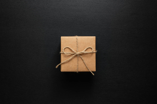gift box tied with string on a dark wooden background - Фото, изображение
