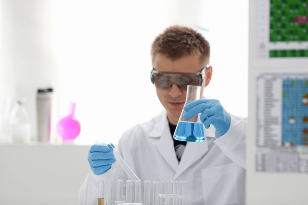 Um químico macho detém tubo de ensaio de vidro em
 - Foto, Imagem