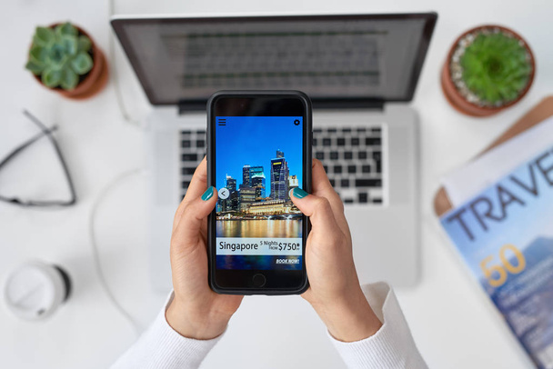 woman holding mobile phone, screen with Singapore city building  - Photo, image