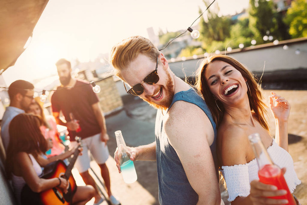 Happy young attractive couple having fun time at party - Fotoğraf, Görsel