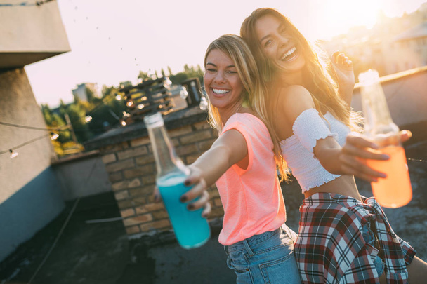 Happy young girls having fun at roof party together - 写真・画像